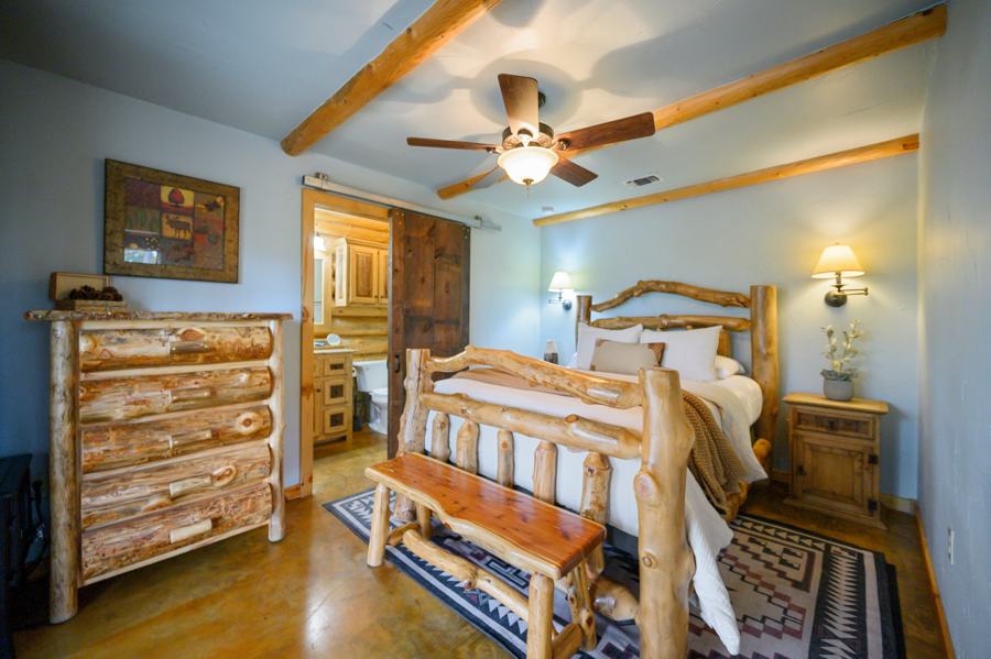 Queen bedroom with log bed and ceiling fan