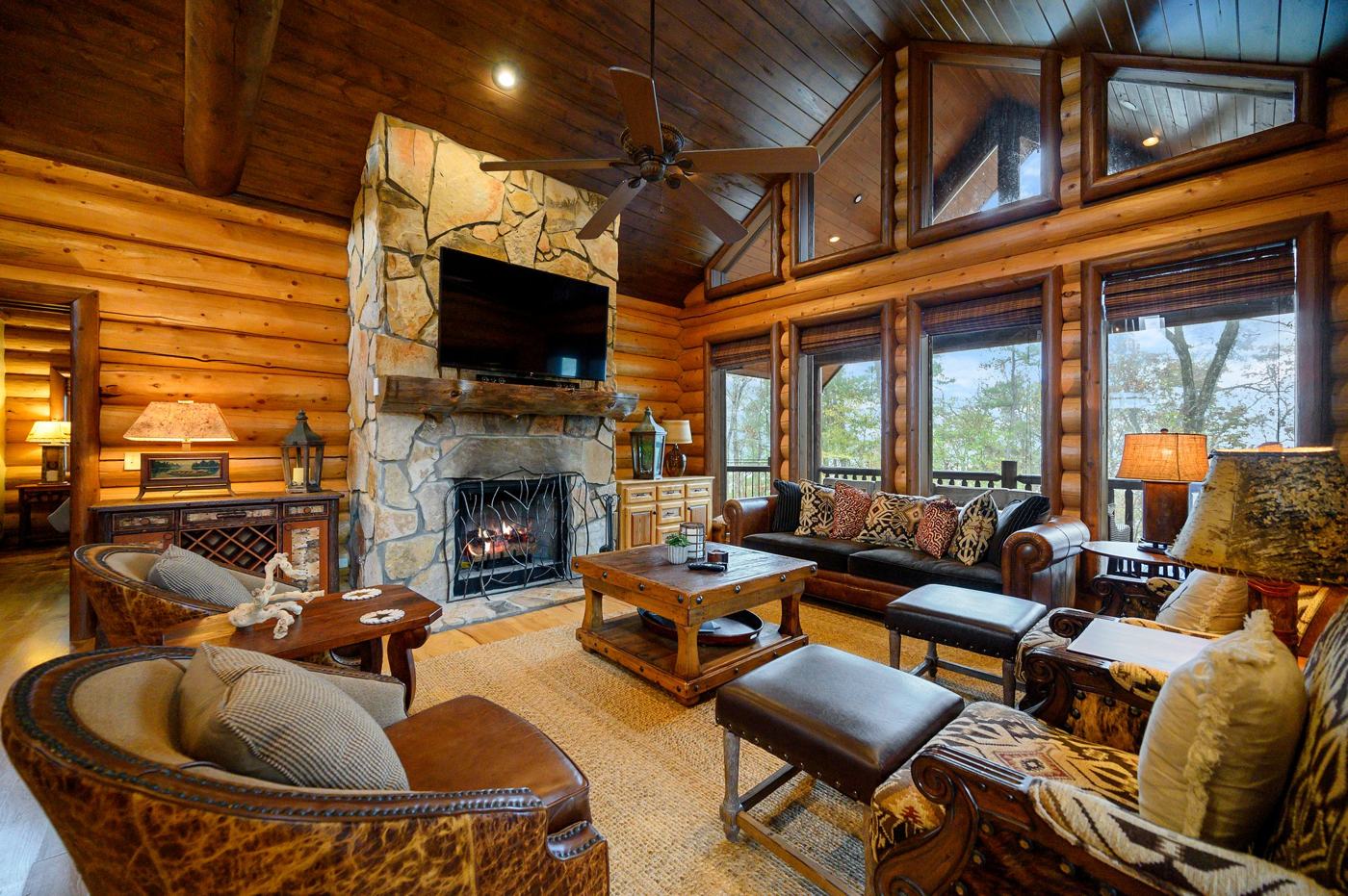 Great room with floor-to-ceiling stone fireplace and log walls